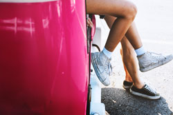 Traveler sitting beside a pink suitcase