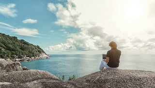 Digital nomad working on a laptop beside the ocean