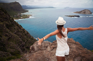 Woman overlooking the Oahu coastline from a mountain viewpoint