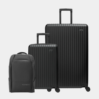 Set of black suitcases and backpack on a light gray background#color_black