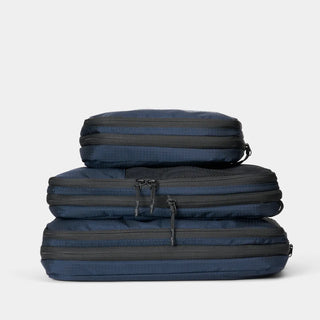 NOMATIC Compression Packing Cubes in navy, compressed and stacked, top view