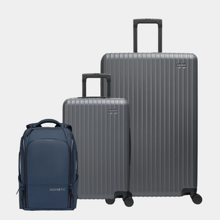 Set of gray suitcases and a blue backpack on a light gray background#color_gray