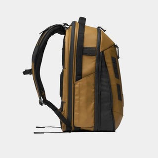 A side profile view of a tactical backpack in tan and black, shown on a clean white background.