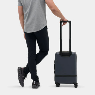 NOMATIC Carry-On Classic in navy, lifestyle photo of a man walking away with the bag