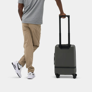 NOMATIC Carry-On Classic in olive, lifestyle photo of a man walking with the bag