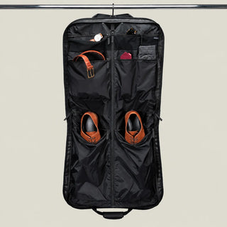 NOMATIC Garment Bag in Black, open flat lay showing interior pockets, shoes, and belt